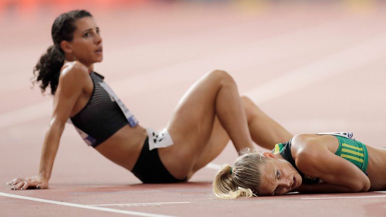 Andrea Seccafien, of Canada, left, and Dominique Scott, of South Africa react after finishing a women's 5000 meter heat at the World Athletics Championships in Doha, Qatar, Wednesday, Oct. 2, 2019. (Petr David Josek/AP)