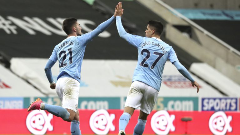 Manchester City's Ferran Torres, left, celebrates with teammate Joao Cancelo after scoring a goal during the English Premier League soccer match between Newcastle United and Manchester City at St James' Park stadium, in Newcastle, England, Friday, May 14, 2021. (Scott Heppell/AP)