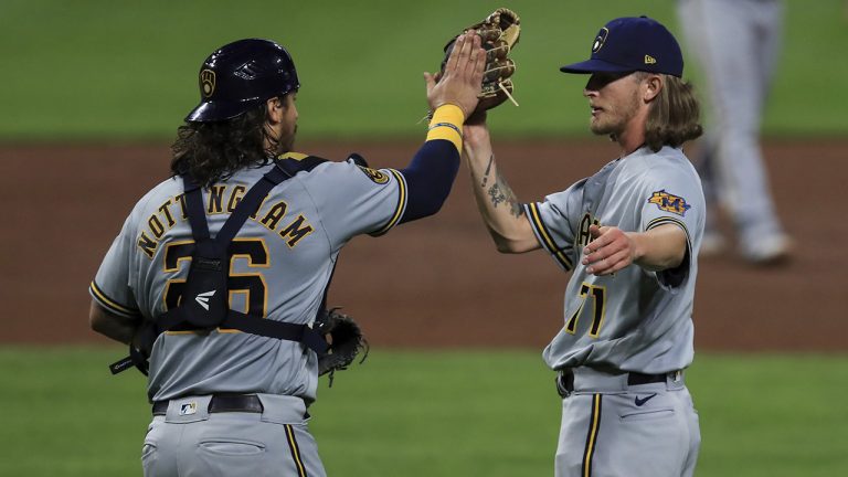Milwaukee Brewers' Jacob Nottingham, left, high fives Josh Hader, right, in the ninth inning during a baseball game against the Cincinnati Reds in Cincinnati, Tuesday, Sept. 22, 2020. (Aaron Doster/AP)