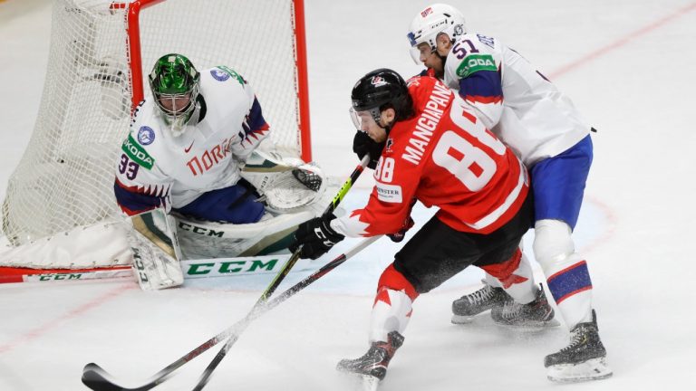 Norway's Mats Rosseli Olsen, right, challenges for the puck with Canada's Andrew Mangiapane during the Ice Hockey World Championship group B match between Canada and Norway at the Arena in Riga, Latvia, Wednesday, May 26, 2021. (Sergei Grits/AP) 