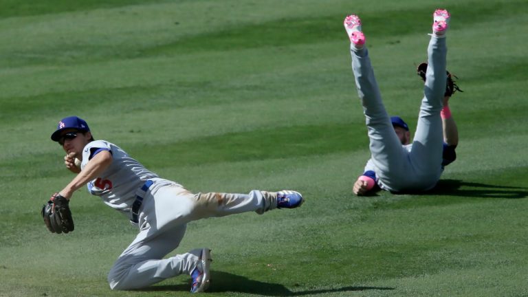 Los Angeles Dodgers shortstop Corey Seager, left, loses his grip on the ball as second baseman Gavin Lux flips over on a single by Los Angeles Angels' Phil Gosselin during the seventh inning of a baseball game in Anaheim, Calif., Sunday, May 9, 2021. (AP Photo/Alex Gallardo)