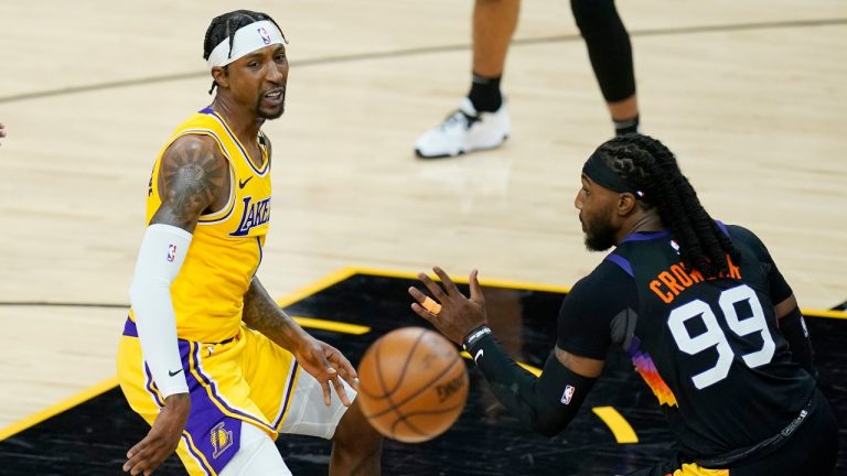 Los Angeles Lakers guard Kentavious Caldwell-Pope, left, gets off a pass sending the ball past Phoenix Suns forward Jae Crowder (99) during the first half of Game 2 of their NBA basketball first-round playoff series Tuesday, May 25, 2021, in Phoenix. (Ross D. Franklin/AP) 