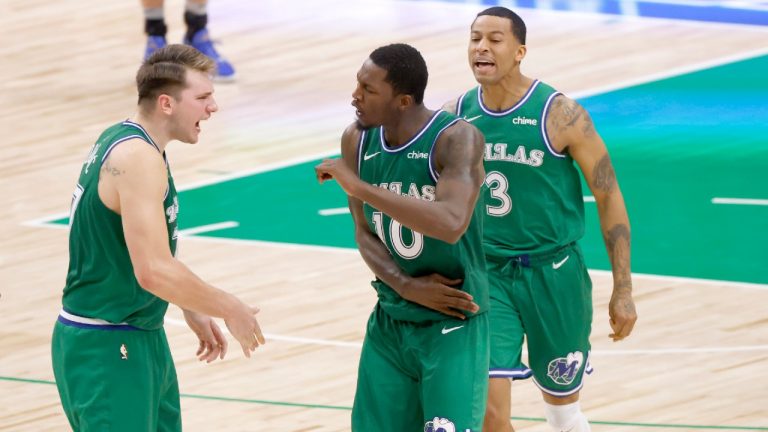 Dallas Mavericks guard Luka Doncic (77), forward Dorian Finney-Smith (10), and guard Trey Burke (3) celebrate after their team took the lead over the Washington Wizards late in the second half of an NBA basketball game Saturday, May 1, 2021, in Dallas. (Ron Jenkins/AP)