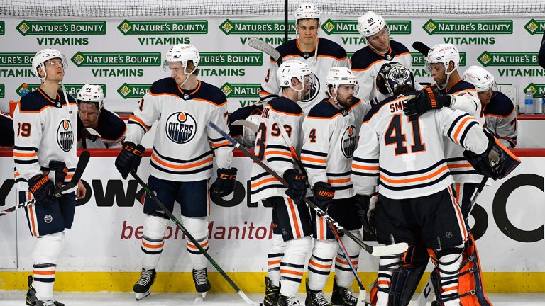 Edmonton Oilers console goaltender Mike Smith (41) after he allowed the game-winning goal during third overtime period Stanley Cup playoff action against the Winnipeg Jets, in Winnipeg on Tuesday, May 25, 2021. (Fred Greenslade/CP) 