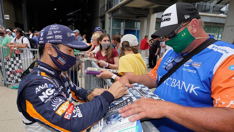 Takuma Sato, of Japan, signs an autograph for a fan during qualifications for the Indianapolis 500 auto race at Indianapolis Motor Speedway, Saturday, May 22, 2021, in Indianapolis. (Darron Cummings/AP)