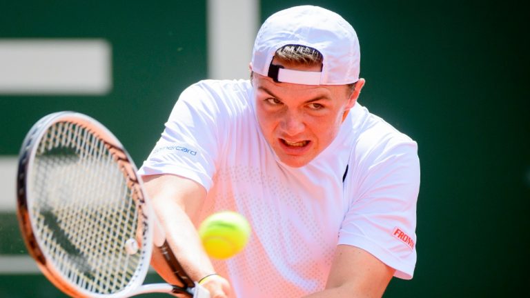 Dominic Stephan Stricker of Switzerland returns a ball to Marton Fucsovics of Hungaria during their round of 16 men's match, at the ATP 250 Geneva Open tournament in Geneva, Switzerland, Wednesday, May 19, 2021. (Laurent Gillieron/Keystone via AP)