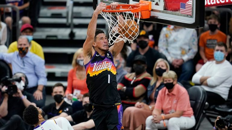 Phoenix Suns guard Devin Booker (1) dunks as he drives past Los Angeles Lakers forward Anthony Davis (3) during the first half of Game 1 of their NBA basketball first-round playoff series Sunday, May 23, 2021, in Phoenix. (Ross D. Franklin/AP)
