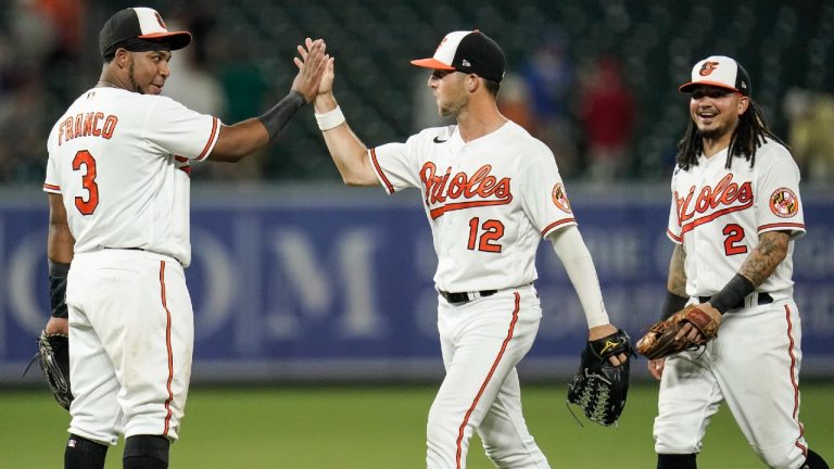 Baltimore Orioles third baseman Maikel Franco (3), center fielder Stevie Wilkerson (12) and shortstop Freddy Galvis (2) react after defeating the New York Mets 10-3 during a baseball game, Tuesday, June 8, 2021, in Baltimore. (Julio Cortez/AP)