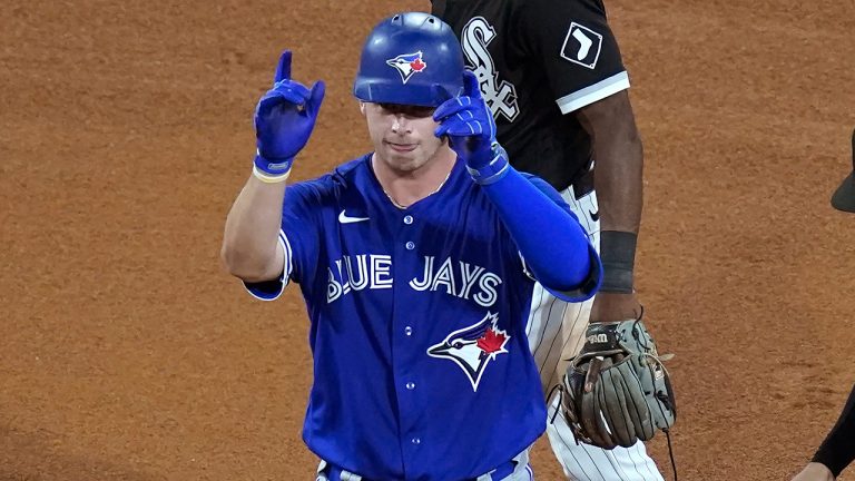 Toronto Blue Jays' Riley Adams celebrates his first hit in the majors, a double off Chicago White Sox starting pitcher Carlos Rodon, as White Sox's Tim Anderson, top, and Nick Madrigal stand nearby during the fifth inning of a baseball game Tuesday, June 8, 2021, in Chicago. (Charles Rex Arbogast/AP) 