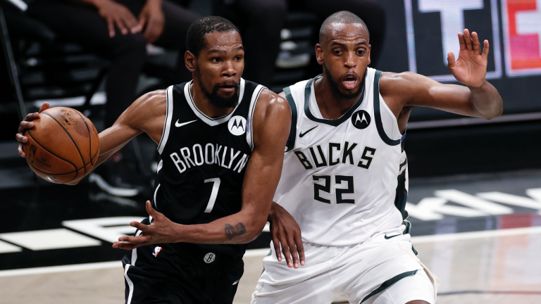 Brooklyn Nets forward Kevin Durant drives to the basket past Milwaukee Bucks forward Khris Middleton. (Adam Hunger / AP) 