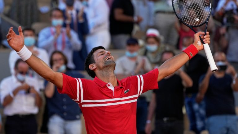 Novak Djokovic celebrates after defeating Stefanos Tsitsipas to win the 19th Grand Slam title of his career. (Michel Euler/AP)