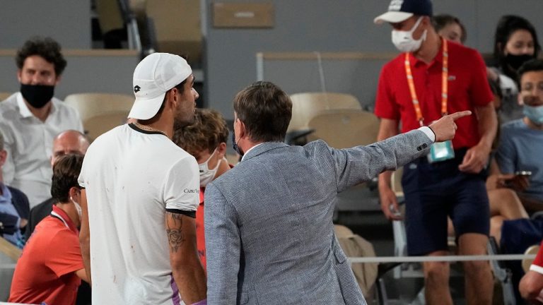 A stadium official asks Italy's Matteo Berrettini to to walk back to the cloakroom, giving time for spectators to leave in accordance of the 11PM curfew due to the COVID-19 pandemic while Italy's Matteo Berrettini played Serbia's Novak Djokovic in a quarterfinal match of the French Open tennis tournament at the Roland Garros stadium Wednesday, June 9, 2021 in Paris. The watch was suspended. (Michel Euler/AP)