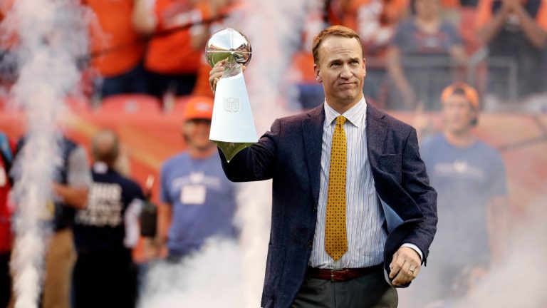 This Sept. 8, 2016, photo shows former Denver Broncos quarterback Peyton Manning carrying the Lombardi Trophy onto the field prior to a game between the Broncos and the Carolina Panthers in Denver. (Jack Dempsey/AP) 