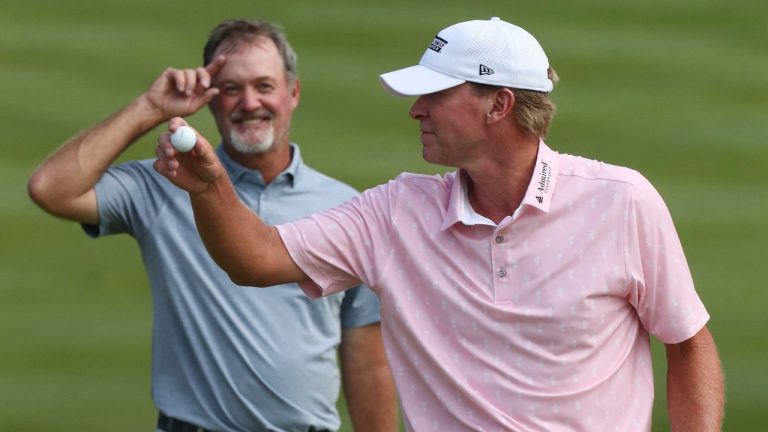 Jerry Kelly, left, watches as Steve Stricker celebrates his win at the Bridgestone Senior Players Championship golf tournament at Firestone Country Club on Sunday, June 27, 2021, in Akron, Ohio. (Mike Cardew/Akron Beacon Journal via AP)