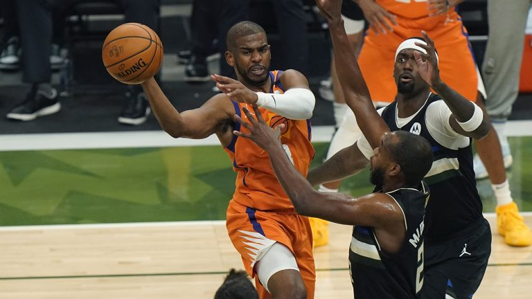 Phoenix Suns guard Chris Paul tries to pass around Milwaukee Bucks forward Khris Middleton during the first half of Game 6 of basketball's NBA Finals in Milwaukee, Tuesday, July 20, 2021. (AP Photo/Paul Sancya)