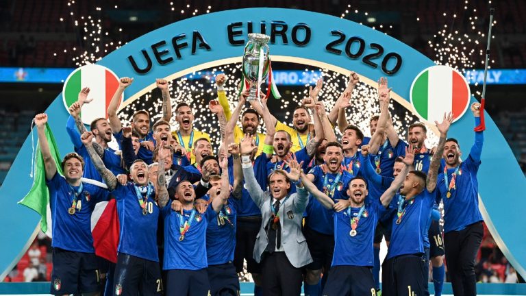 Italy's team celebrates with the trophy on the podium after winning the Euro 2020 soccer championship final between England and Italy at Wembley stadium in London, Sunday, July 11, 2021. (Michael Regan/Pool via AP) 
