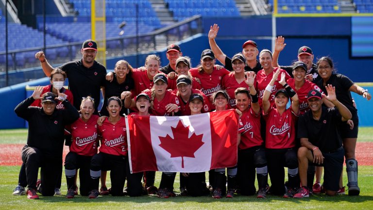 Members of team Canada pose for photographs after a softball game against Mexico at the 2020 Summer Olympics. (Sue Ogrocki/AP)