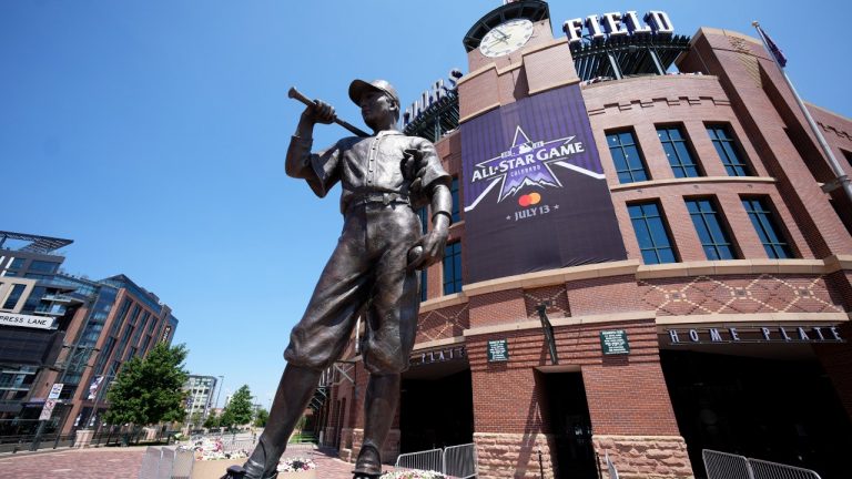 A banner for the All-Star game hangs on the front of Coors Field near the sculpture entitled "The Player" after a news conference to kick off All-Star week Wednesday, July 7, 2021, in Denver. (David Zalubowski/AP)