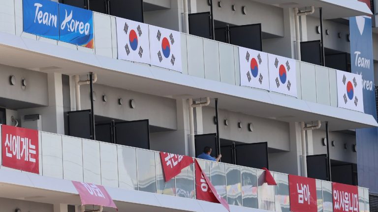 Banners with the words "I still have the support of 50 million Korean people," are removed from balconies at the the Olympic athletes' village in Tokyo Saturday, July 17, 2021. South Korea's Olympic Committee said Saturday it has removed banners at the Olympic athletes' village in Tokyo that called up a 16th-century war between Korea and Japan after the International Olympic Committee ruled it was provocative. (Jin Sung-chul/Yonhap via AP) 