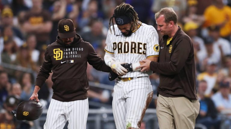 San Diego Padres' Fernando Tatis Jr., centre, is helped off the field by manager Jayce Tingler, left, and a trainer during the first inning of the team's baseball game against the Colorado Rockies, Friday, July 30, 2021, in San Diego. (Derrick Tuskan/AP)