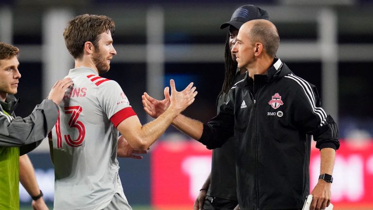 Toronto FC interim coach Javier Perez, right, is congratulated by forward Patrick Mullins (13) at the conclusion of the second half of an MLS soccer match against the New England Revolution. (Charles Krupa/AP) 