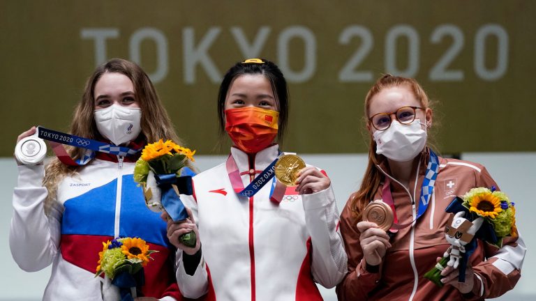 Silver medalist Anastasiia Galashina, left, of the Russian Olympic Committee, gold medalist Yang Qian, of China, center, and bronze medalist Nina Christen, of Switzerland stand after the women's 10-meter air rifle at the Asaka Shooting Range in the 2020 Summer Olympics. (Alex Brandon/AP) 