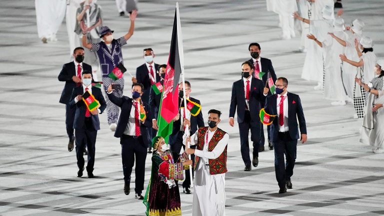 Kimia Yousofi and Farzad Mansouri, of Afghanistan, carry their country's flag during the opening ceremony in the Olympic Stadium at the 2020 Summer Olympics, Friday, July 23, 2021. (David J. Phillip/AP)