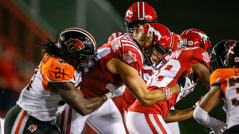 BC Lions' Jordan Williams, left, grabs Calgary Stampeders' Ante Milanovic-Litre during second half CFL football action in Calgary, Thursday, Aug. 12, 2021. (Jeff McIntosh/CP)