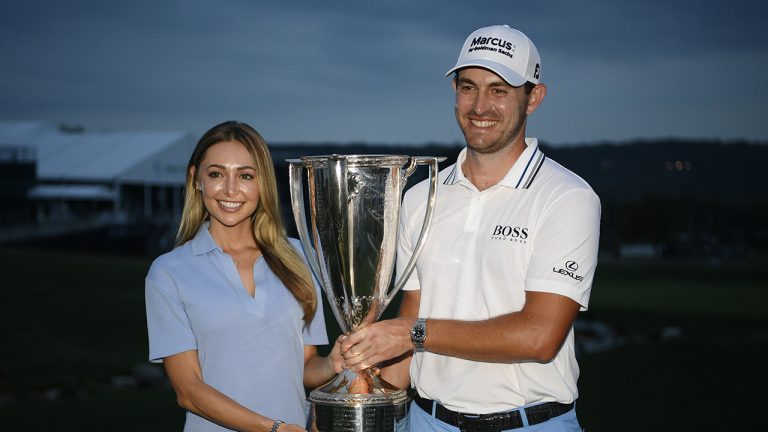 Patrick Cantlay, right, poses with his girlfriend, Nikki Guidish and the FedEx Cup after he won the BMW Championship golf tournament, Sunday, Aug. 29, 2021, at Caves Valley Golf Club in Owings Mills, Md. (Nick Wass/AP)