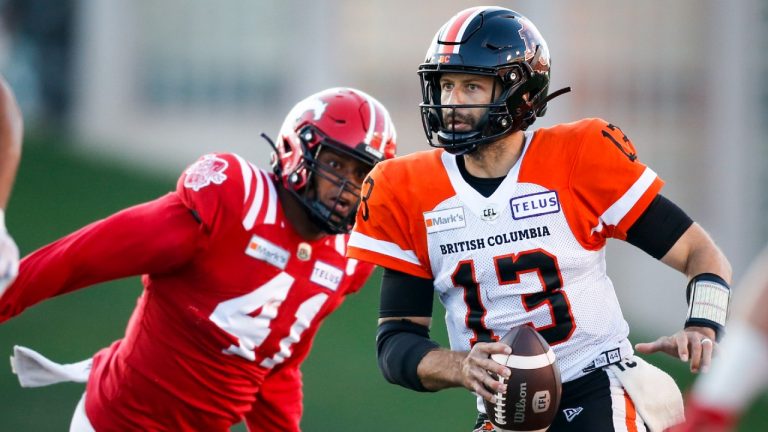 BC Lions quarterback Michael Reilly, right, runs the ball as the Calgary Stampeders' Mike Rose closes in. (Jeff McIntosh/CP)