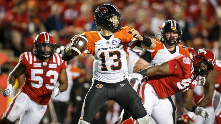 BC Lions' quarterback Michael Reilly, centre, throws the ball as Calgary Stampeders close in during second half CFL football action in Calgary, Thursday, Aug. 12, 2021. (Jeff McIntosh/CP)