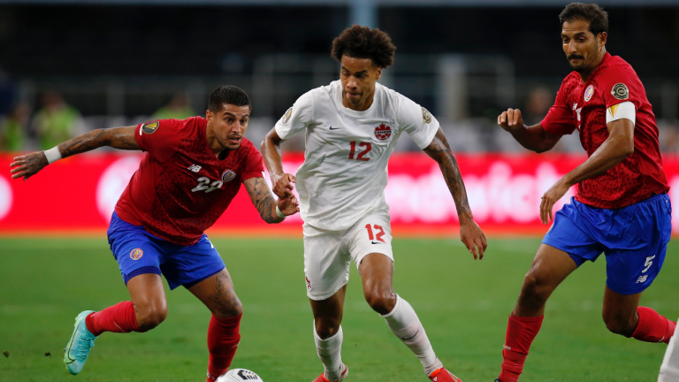 Costa Rica defender Ronald Matarrita (22) keeps control of the ball while under pressure from Canada forward Tajon Buchanan (12) as teammate Borges (5) looks on in the first half of a 2021 CONCACAF Gold Cup quarterfinals soccer match, Sunday, July 25, 2021, in Arlington, Texas. (Brandon Wade / AP)