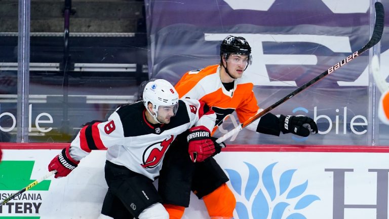 New Jersey Devils' Will Butcher (8) and Philadelphia Flyers' Travis Sanheim (6) collide during the second period of an NHL hockey game, Monday, May 10, 2021, in Philadelphia (Matt Slocum/AP).
