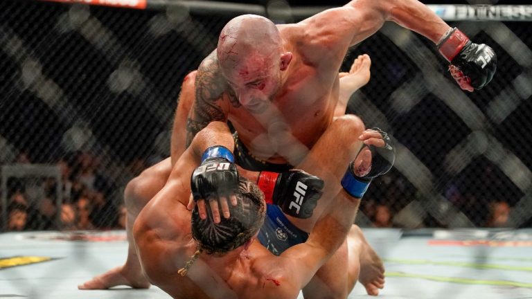 Alexander Volkanovski, top, punches Brian Ortega during a featherweight mixed martial arts title bout at UFC 266 in Las Vegas. (John Locher/AP)