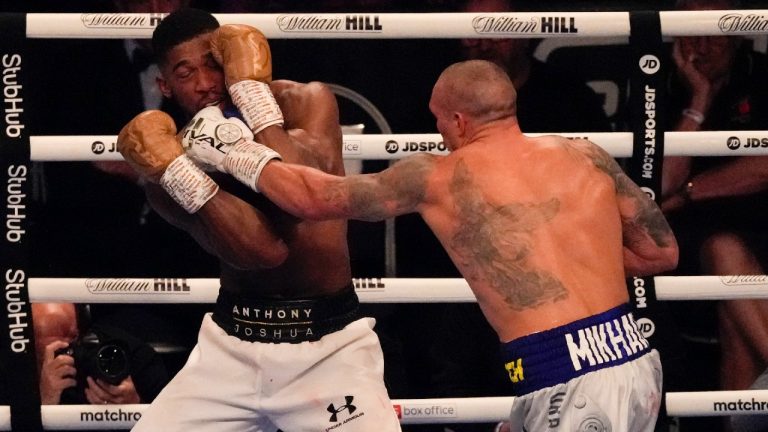 Oleksandr Usyk of Ukraine hits Anthony Joshua of Britain during their WBA (Super), WBO and IBF boxing title bout at the Tottenham Hotspur Stadium in London, Saturday, Sept. 25, 2021. (Frank Augstein/AP)