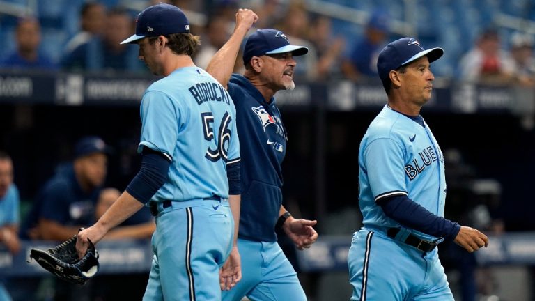 Toronto Blue Jays manager Charlie Montoyo, right, and pitching coach Pete Walker, centre, run onto the field after starting pitcher Ryan Borucki, left, was ejected after hitting Tampa Bay Rays' Kevin Kiermaier with a pitch during the eighth inning of a baseball game Wednesday, Sept. 22, 2021, in St. Petersburg, Fla (Chris O'Meara/AP).