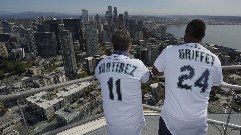 Former Seattle Mariners players Edgar Martinez, left, and Ken Griffey Jr., right, look out over the Seattle skyline after they raised a flag for the 2023 MLB All-Star Game on the roof of the Space Needle, Thursday, Sept. 16, 2021, in Seattle. (Ted S. Warren/AP)