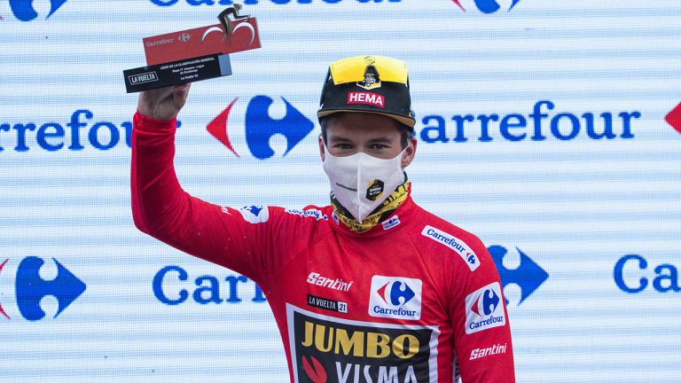 Primoz Roglic wearing the leader's red jersey  celebrates on the podium. (Lalo R. Villar/AP)