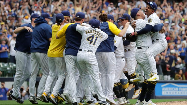 Milwaukee Brewers' Avisail Garcia hugs Eduardo Escobar, right, as the team celebrates on the field after a baseball game against the New York Mets Sunday, Sept. 26, 2021, in Milwaukee. The Brewers clinched the National League Central Division. (Aaron Gash/AP) 