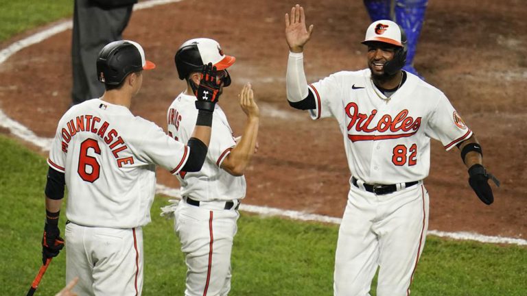 Baltimore Orioles' Kelvin Gutierrez, right, and Ramon Urias, center, are greeted by Ryan Mountcastle near the plate after scoring on an error by Kansas City Royals right fielder Hunter Dozier on a fly ball hit by Orioles designated hitter Cedric Mullins during the eighth inning of baseball game. (Julio Cortez/AP)