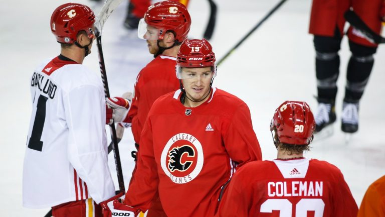 Calgary Flames' Matthew Tkachuk, centre, chats with teammates during opening day of training camp in Calgary, Thursday, Sept. 23, 2021. (Jeff McIntosh/THE CANADIAN PRESS)