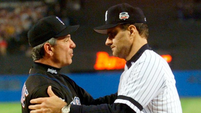 In this Oct. 21, 2000, file photo, New York Yankees manager Joe Torre, right, greets New York Mets manager Bobby Valentine before the start of Game 1 of baseball's World Series at Yankee Stadium in New York. Sports teams will hold ceremonies Saturday, Sept. 11, 2021, to mark the 20th anniversary of the Sept. 11 terrorist attacks. Valentine, manager of the 2001 Mets, will throw a ceremonial first pitch to Torre, manager of the 2001 Yankees. (Mark Lennihan, Pool/AP) 