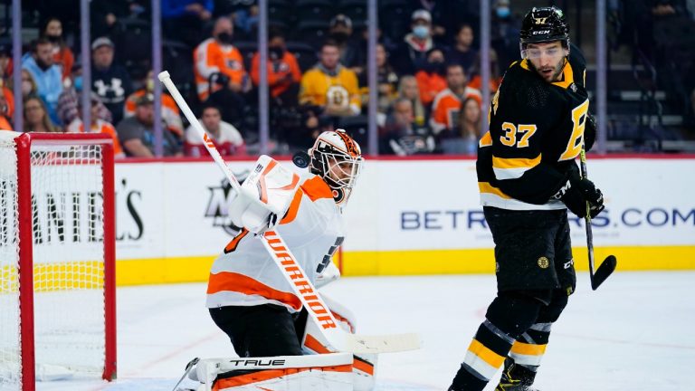 Philadelphia Flyers' Martin Jones, left, blocks a shot behind Boston Bruins' Patrice Bergeron during the first period of an NHL hockey game, Wednesday, Oct. 20, 2021, in Philadelphia. (Matt Slocum/AP)