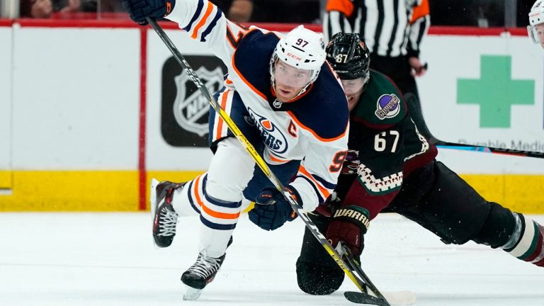 Edmonton Oilers center Connor McDavid (97) works against Arizona Coyotes left wing Lawson Crouse (67) for the puck during the second period of an NHL hockey game Thursday, Oct. 21, 2021, in Glendale, Ariz. (Ross D. Franklin/AP)