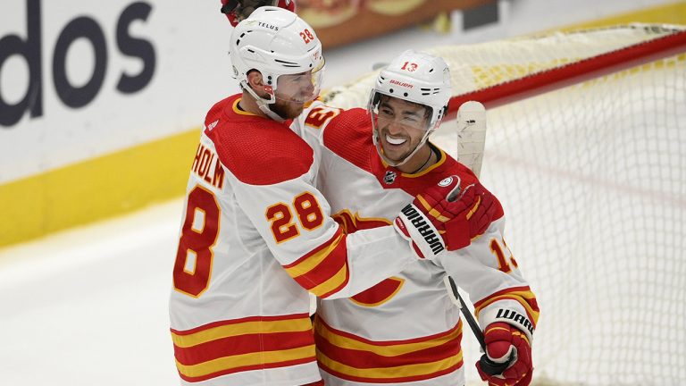 Calgary Flames centre Elias Lindholm (28) celebrates with left wing Johnny Gaudreau (13) after scoring the game-winning goal in overtime of an NHL hockey game against the Washington Capitals. (Nick Wass/AP)
