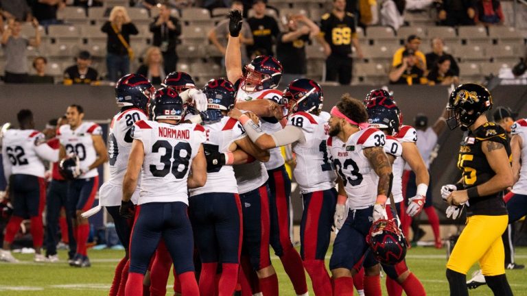 Montreal Alouettes players swarm Montreal Alouettes kicker David Côté (15) after his game-winning filed goal during overtime CFL football game action against the Hamilton Tiger Cats in Hamilton, Ont. on Saturday, October 2, 2021 (Peter Power/CP).