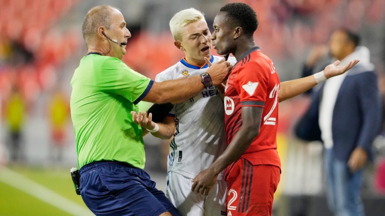 Toronto FC's Richie Laryea and FC Cincinnati's Alvaro Barreal, centre, exchange words during the first half of MLS soccer action in Toronto, Wednesday September 29, 2021 (Mark Blinch/CP).