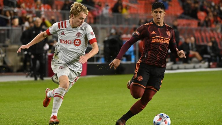 Toronto FC's Jacob Shaffelburg, left, and Atlanta United's Alan Franco race for the ball during second half MLS soccer action in Toronto on Saturday, Oct. 16, 2021. (Jon Blacker/CP)