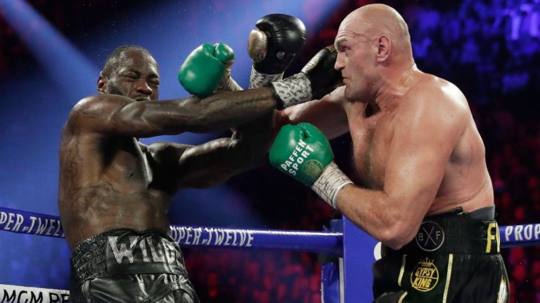 Tyson Fury, right, hits Deontay Wilder during a WBC heavyweight championship boxing match. (Isaac Brekken/AP)