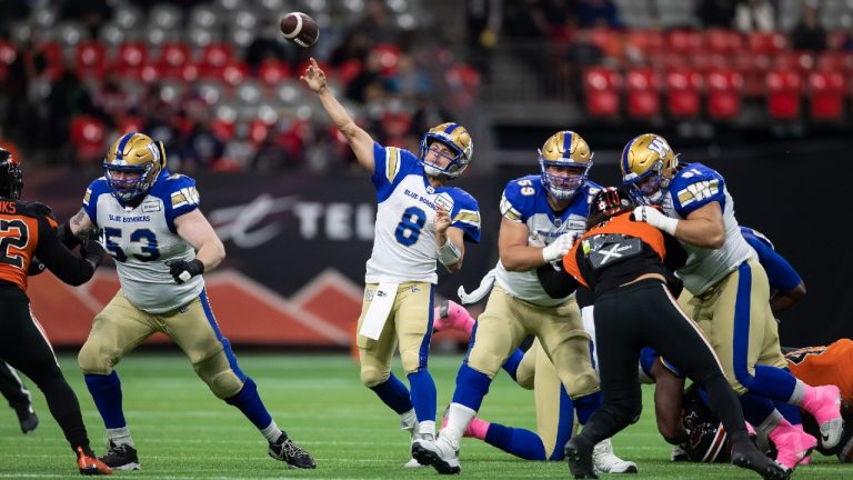 Winnipeg Blue Bombers quarterback Zach Collaros (8) passes as Michael Couture (59) and Drew Desjarlais (61) hold off B.C. Lions' J.R. Tavai (10) during the first half of a CFL football game in Vancouver, on Friday, October 1, 2021. (Darryl Dyck/CP)